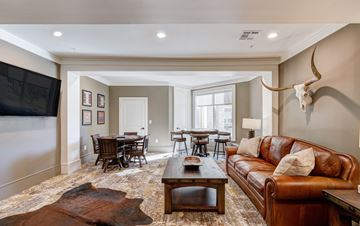 Katy apartment for rent - A living room with a brown leather couch and a cow skull mounted on the wall.
