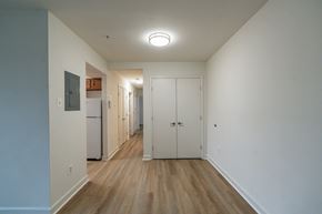 Washington apartment for rent - A long hallway with a refrigerator on the left and a door on the right.