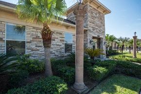 Mcallen apartment for rent - a house with columns and palm trees in front of it