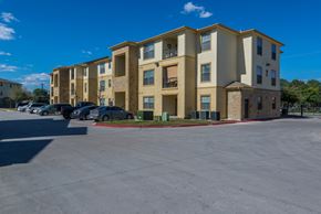 San Antonio apartment for rent - a large apartment building with cars parked in front of it