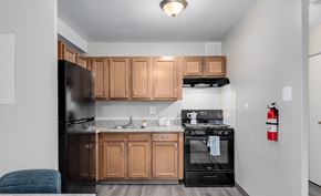 Washington apartment for rent - A kitchen with black appliances and wooden cabinets.