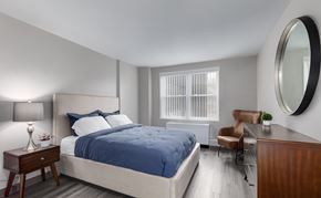 Washington apartment for rent - A bedroom with a bed, chair, and lamp.