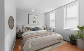 Haverhill apartment for rent - A bedroom with a large bed and a potted plant.