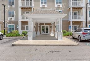 Haverhill apartment for rent - A white covered walkway leads to a building with a white entrance.