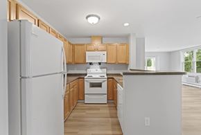 Tyngsborough apartment for rent - A kitchen with wooden cabinets and a white refrigerator.