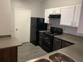 San Antonio apartment for rent - Modern kitchen with black appliances and white cabinets at Port Royal Apartments Homes, San Antonio, TX 78242