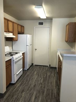 Mission apartment for rent - A kitchen with white appliances and wood cabinets.