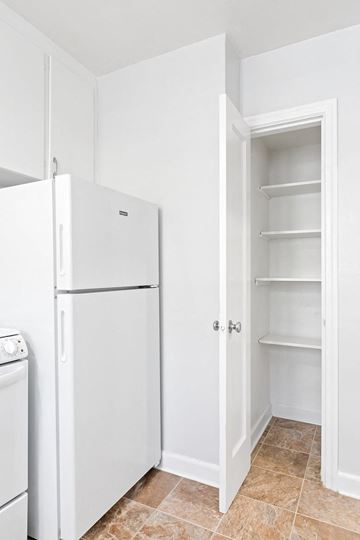 Shelton apartment for rent - A white kitchen with a refrigerator, dishwasher and an open pantry door.