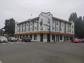 Shelton apartment for rent - a white building with a brown roof and cars parked in front of it