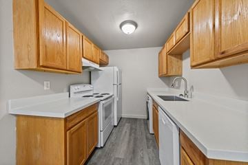 Lakewood apartment for rent - A kitchen with wooden cabinets and white appliances.
