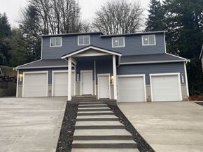 Tumwater townhouse for rent - A blue house with white garage doors and a covered entryway.