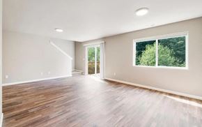Tumwater townhouse for rent - A spacious room with wooden flooring and a large window.