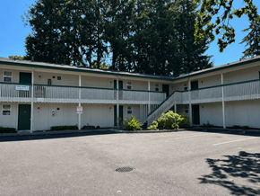 Lakewood apartment for rent - A parking lot in front of a white building with green doors.