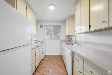 Tacoma apartment for rent - A kitchen with a white refrigerator and white cabinets.