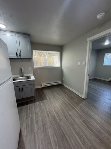 Seattle apartment for rent - A kitchen with a white refrigerator and grey cabinets.