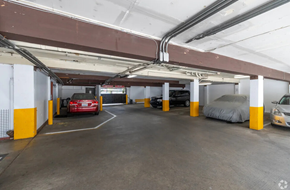 Seattle apartment for rent - A parking garage with a red car in the center.
