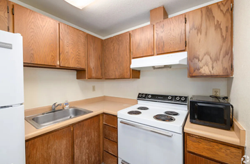 Seattle apartment for rent - A kitchen with a white stove and wooden cabinets.