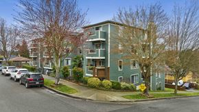 Seattle apartment for rent - a green apartment building with cars parked in front of it