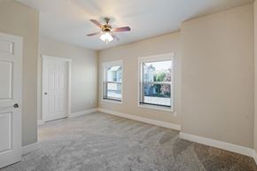 Tumwater apartment for rent - Bedroom with ceiling fan, closet, windows, and carpet at Hearthstone Apartments