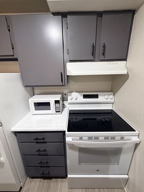 Seattle apartment for rent - A white microwave oven is on a countertop above a stove.