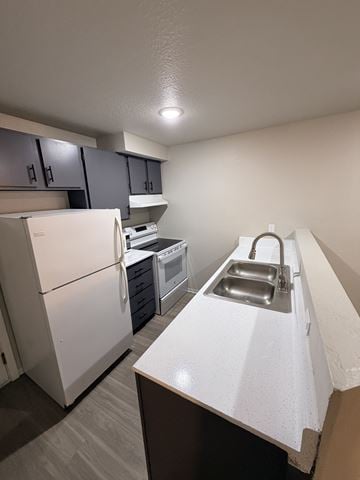 Seattle apartment for rent - A white refrigerator is in a kitchen with a white counter.