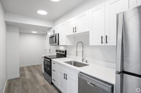 Seattle apartment for rent - A modern kitchen with white cabinets and stainless steel appliances.