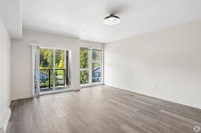 Seattle apartment for rent - A spacious room with a sliding glass door leading to a backyard.