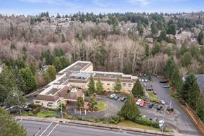 Bellevue apartment for rent - an aerial view of a building with a parking lot and trees