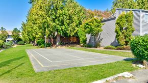 Everett apartment for rent - A tennis court surrounded by green grass and trees.