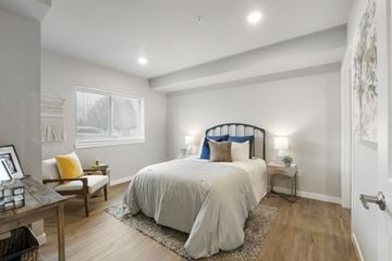 Puyallup apartment for rent - A bedroom with a large bed and a window with blinds.