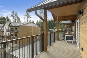 Lacey apartment for rent - A wooden deck with a metal railing and a hot tub.