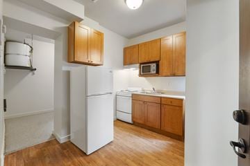 Seattle apartment for rent - A kitchen with wooden cabinets and white appliances.