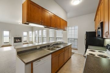 Seattle apartment for rent - A kitchen with brown cabinets and a black refrigerator.