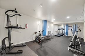 Bellevue apartment for rent - a gym with weights and exercise equipment in a room with white walls