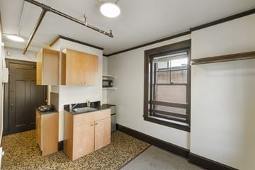 Seattle apartment for rent - A kitchen area with wooden cabinets and a black countertop.