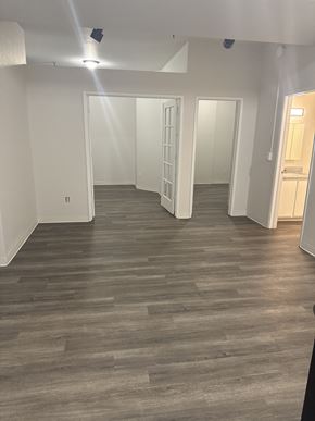 Olympia apartment for rent - A room with wooden flooring and white walls.