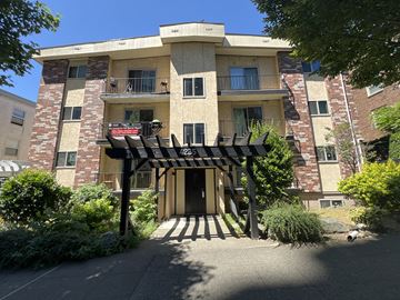 Seattle apartment for rent - A building with a black and white striped awning in front.