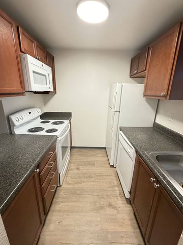 Lakewood apartment for rent - A kitchen with brown cabinets and a white stove top oven.