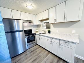 Tacoma apartment for rent - A kitchen with white cabinets and a marble countertop.