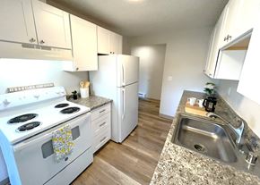 Lakewood apartment for rent - A kitchen with a white stove top oven and a white refrigerator.