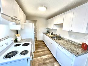 Lakewood apartment for rent - A kitchen with white cabinets and a white stove top oven.