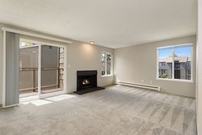 Everett apartment for rent - A living room with a fireplace and sliding glass door to balcony in 2 bedroom apartment.