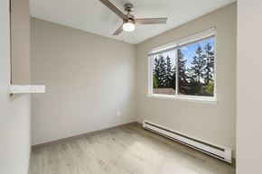 Everett apartment for rent - A dining room with a window showing trees outside and wood plank flooring.