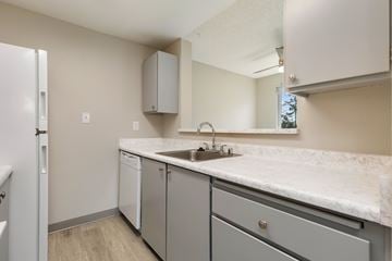 Everett apartment for rent - A kitchen with a white counter top and grey cabinets.
