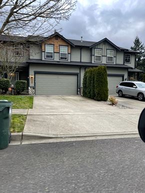 Olympia townhouse for rent - A grey house with a grey car parked in front.