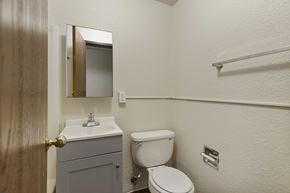Seattle apartment for rent - A bathroom with a toilet, sink, and mirror.