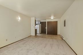 Seattle apartment for rent - A spacious room with a carpeted floor and two doors.