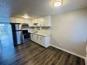 Tacoma apartment for rent - A kitchen with white cabinets and a wooden floor.