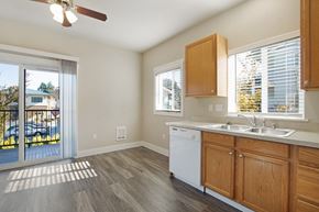 Tumwater apartment for rent - Kitchen with oak cabinets and light color countertops and wood plank vinyl flooring at Hearthstone Apartments