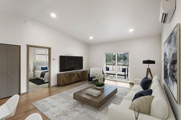 Lacey apartment for rent - A modern living room with a white sofa, a coffee table, and a large painting on the wall.